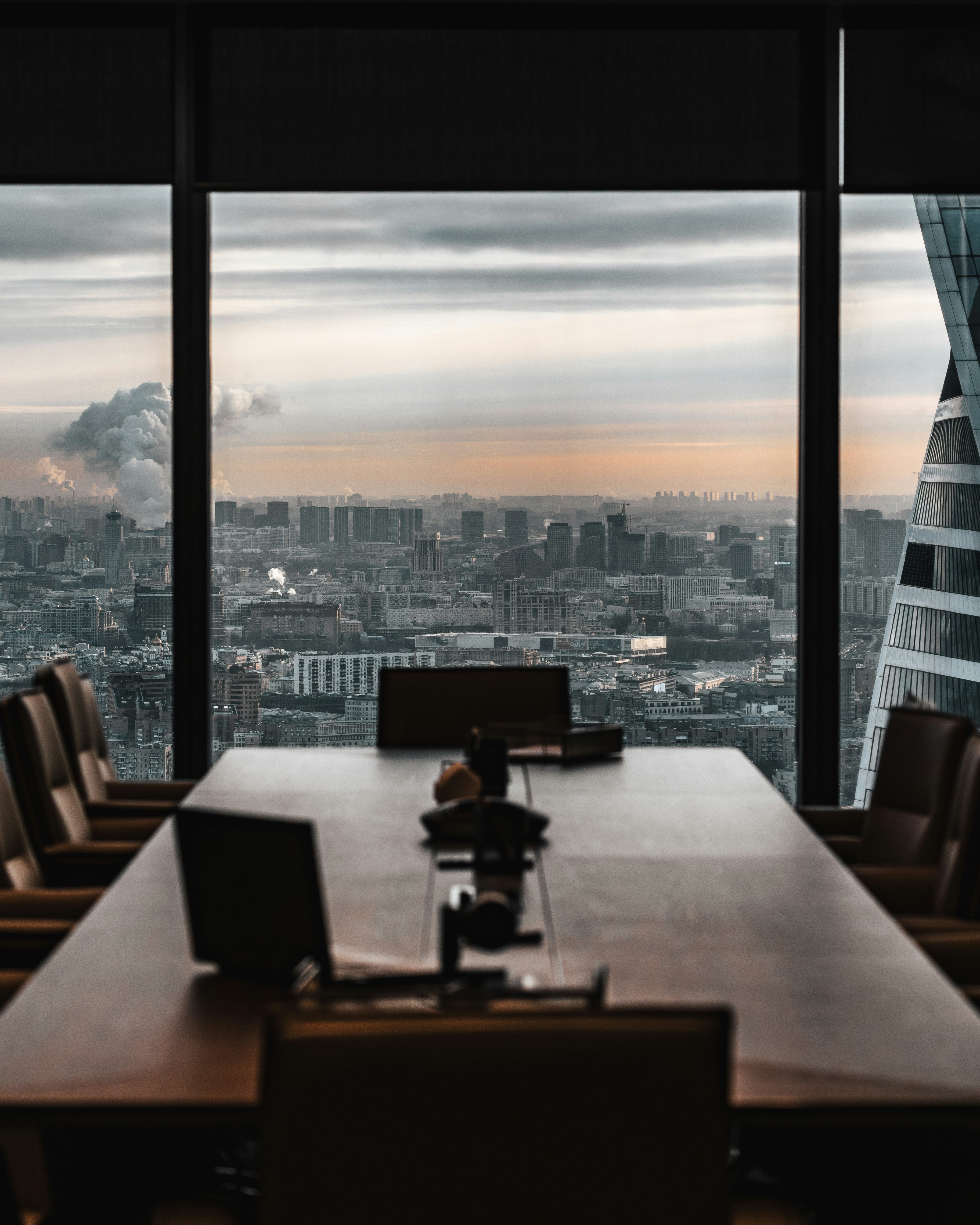 Empty corporate boardroom with city skyline view at dusk