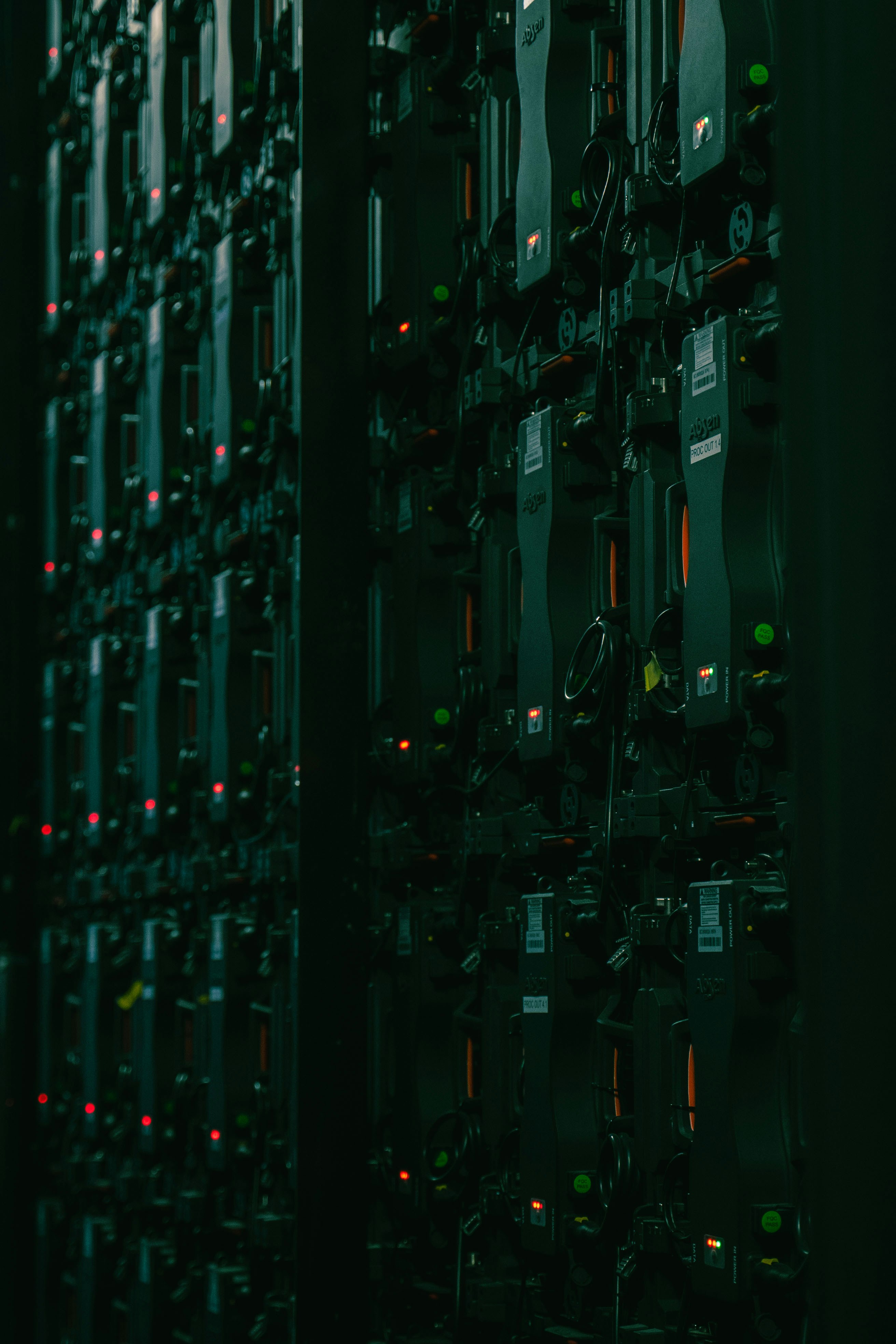 Dark server room with rows of computing equipment and subtle indicator lights